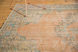 Distressed vintage Oushak carpet with dusty peach field and faded floral motifs.