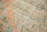 Worn pile texture of a distressed Oushak rug, showing dusty peach, mint, and ivory.