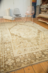 Traditional Oushak rug corner detail, with ivory spandrel and dark bronze floral border.