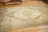 Hand-knotted vintage Oushak corner with curvilinear bronze border and ivory motifs.