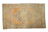 Distressed vintage Oushak rug, faded peach and apricot field, scalloped medallion in muted blue, green, ivory.