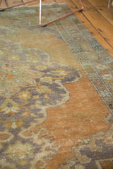 Distressed texture of vintage Oushak rococo medallion in faded peach and royal blue.