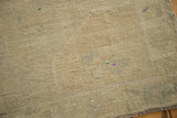 Close-up of the hand-knotted Oushak rug's even ivory pile, showing subtle color variations.