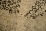 Dark chocolate brown stepped patterns and curvilinear floral motifs on vintage Oushak carpet's antique ivory field.