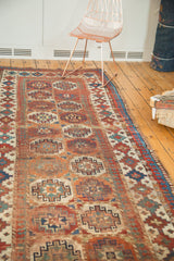 Antique Moghan Kazak runner with repeating gul motifs, Laleh Abassi border, red, green, and ivory.
