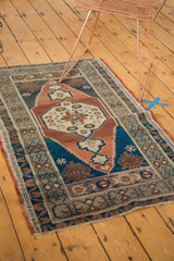 Corner of Vintage Oushak rug showing navy blue field and meandering leaf-flower border.