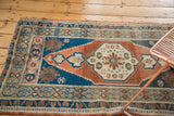 Turkish Oushak rug with unique stepped spandrels and meandering leaf border.