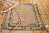 Vintage Oushak Prayer rug corner, showing apricot, blue, and green geometric border designs.