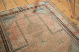Vintage Oushak Prayer rug's pale blush field and intricate blue checker motif within the niche.