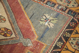 Distressed Oushak runner pile with geometric pinwheel motif, oxidized silver field, and foundation showing.