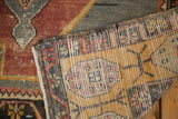Distressed Oushak runner corner reveals hand-knotted backing and worn dusty red pile.