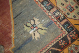Distressed Oushak rug detail: visible wear on an oxidized silver field with a pinwheel motif.