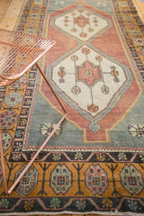 Distressed Oushak runner corner with oxidized silver spandrel and floral gold border.