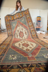 Distressed Oushak runner with double medallion, geometric vinery, and rich floral borders.