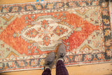 Distressed Oushak runner's faded cherry red and ivory diamond medallion with germinating plants.