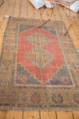 Distressed Oushak rug's faded cinnabar red and dark sand decorative border with secured ends.