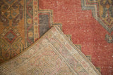Distressed Oushak rug, faded cinnabar red pile texture and hand-knotted foundation.