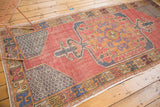 Distressed Oushak runner corner with serpent-inspired border, starburst spandrel, faded red, charcoal blue.