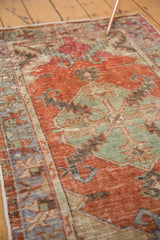 Textured vintage Oushak rug with faded madder root red field and distressed slate blue medallion.