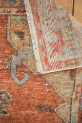 Distressed Oushak runner's cherry red pile texture and visible hand-knotted foundation.
