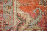 Distressed Oushak runner detail, with worn pile and serrated red, blue, and sand patterns.