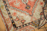 Distressed Oushak rug detail showing faded brick red, ivory tones, and woven texture.