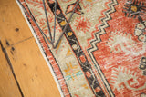 Distressed Oushak rug with faded brick red, ivory low pile, and charcoal stepped border pattern.