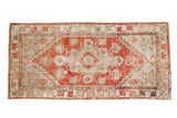 Distressed Oushak runner with cherry red, platinum, and ivory geometric medallion.