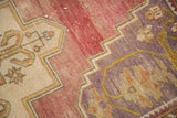 Abrash texture on vintage Oushak rug, showing mauve, ivory, and sage floral geometry.