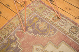 Vintage Oushak rug corner, abraded mauve field, germinating flower and cross-section border.