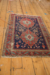 Antique Heriz rug corner: fine indigo field, elaborate serrated leaf border, and tattered fringe.