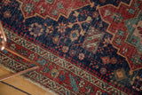 Antique Heriz rug detail showing Laleh Abassi pawn motif, worn texture, and fringe.