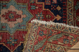 Antique Heriz rug with finely woven foundation, cherry red pile, blush patterns, and tattered fringe.