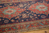 Finely woven antique Heriz rug detail: indigo blue field, cherry red leaves, and geometric motifs.