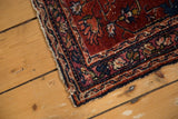 Finely woven vintage Lilihan rug corner with wine red field and tattered indigo border.