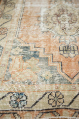 Distressed vintage Oushak runner pile with pale peach, ivory, and slate blue patterns.