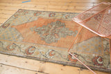 Worn texture and geometric medallion detail on a vintage distressed Oushak rug.
