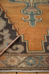 Vintage Oushak rug detail: faded orange field, slate blue rococo contour, low pile.