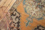 Burnt orange and beige Oushak rug with rococo scalloped contours and low pile.