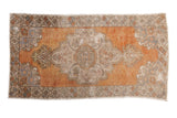 Distressed Oushak carpet with faded tangerine orange, ivory medallion, palmettes, and slate blue.