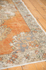 Distressed Oushak carpet with faded tangerine, ivory, and slate blue Rococo motifs.