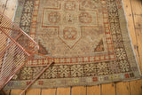 Rectilinear hook and latch border with faded terra cotta, sand, and ivory on a distressed Anatolian runner.