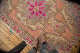 Distressed Oushak rug corner with rococo spandrel in ivory, pink, and slate blue.