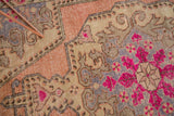 Distressed bright fluorescent pink floral motifs and rococo elements on vintage Oushak rug.
