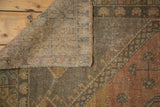 Distressed vintage Oushak rug foundation, secured edge, and low pile with burnt orange accents.