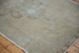 Faded ivory and platinum distressed Oushak rug surface with visible low pile and foundation.