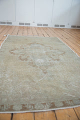 Distressed Oushak rug's faded bronze border and mostly even worn pile texture.