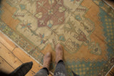 Distressed vintage Oushak runner showcasing faded apricot, sandalwood, and teal tones with even wear.