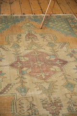 Distressed texture of the vintage Oushak runner's faded apricot and teal medallion pattern.