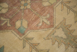 Distressed texture and stepped patterns of a vintage Oushak rug in apricot, teal, and sand.